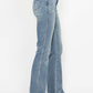 Side view of plus size bootcut jeans showcasing tummy control and embroidered pockets, perfect for a stylish look.