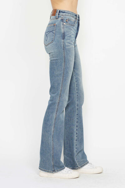 Side view of plus size bootcut jeans showcasing tummy control and embroidered pockets, perfect for a stylish look.