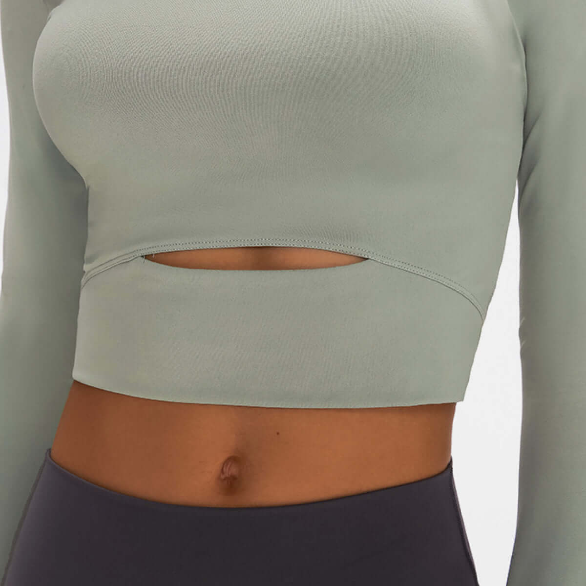 Millennia Long Sleeve Cropped Top in soft green with sports strap detail, perfect for comfort and support during workouts.