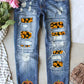 Distressed straight jeans with pumpkin sequin patches, featuring slight stretch for comfort, made of cotton, polyester, and elastane, displayed with flowers.