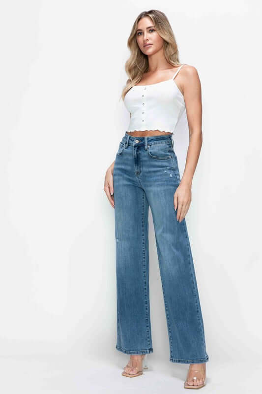 Woman wearing bytos high rise wide leg jeans with pockets, styled with a white crop top and heels for a chic look.