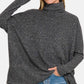 Cozy Zenana brushed melange hacci turtleneck sweater with elegant design, paired with jeans for stylish comfort.