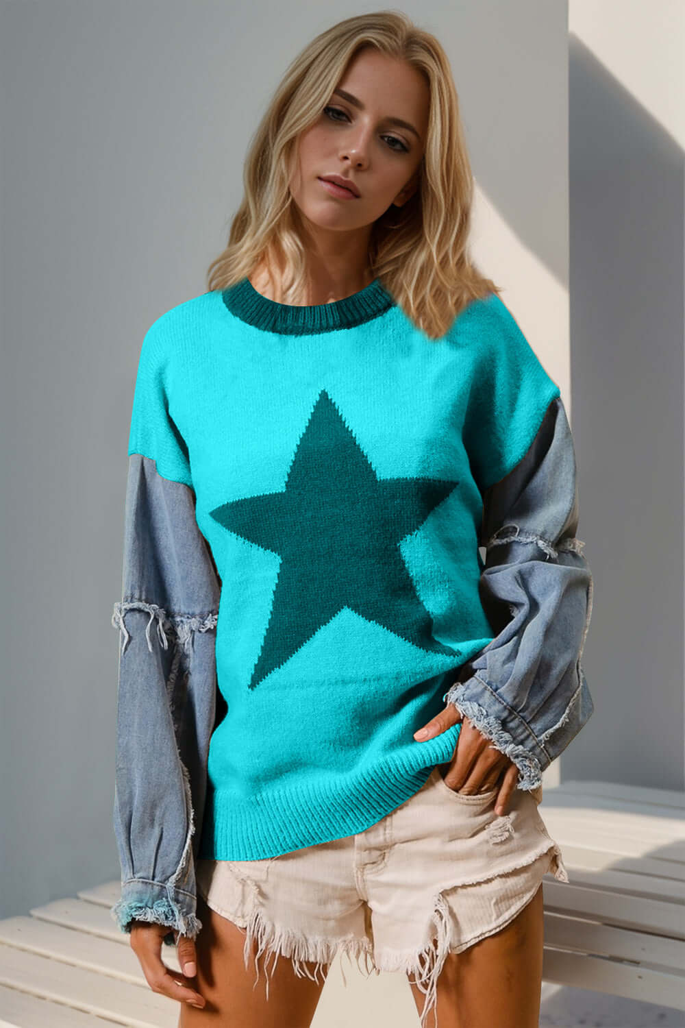 Woman wearing Double Take Full Size Star Pattern Raw Edge Long Sleeve Sweater in vibrant blue with denim sleeves.