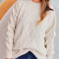 Woman wearing Bella Road Diamond Round Neck Long Sleeve Sweater in white with blue jeans