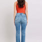 Back view of woman in Judy Blue high waist vintage wash bootcut jeans with side slits, styled with a red tank top.