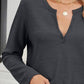 Woman wearing Bella Road waffle-knit notched long sleeve t-shirt in dark gray, accessorized with gold necklace.