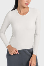 Model wearing a Millennia Round Neck Long Sleeve Sports Top in light color, showcasing a stylish and comfortable fit for workouts.