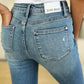 Back view of a person wearing mid-rise Judy Blue distressed jeans with destroyed hem detailing.