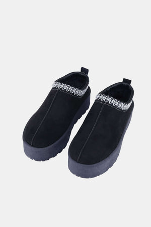 Platform slip-on boots with embroidered trim and thick soles, perfect for stylish and comfortable daily wear or nights out.