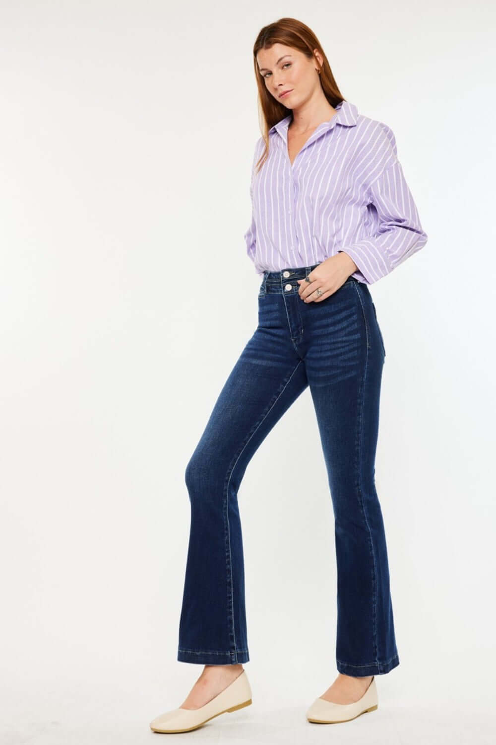 Woman wearing Kancan High Rise Double Waistband Flare Jeans in dark wash with a striped shirt, showcasing sleek and modern denim style.