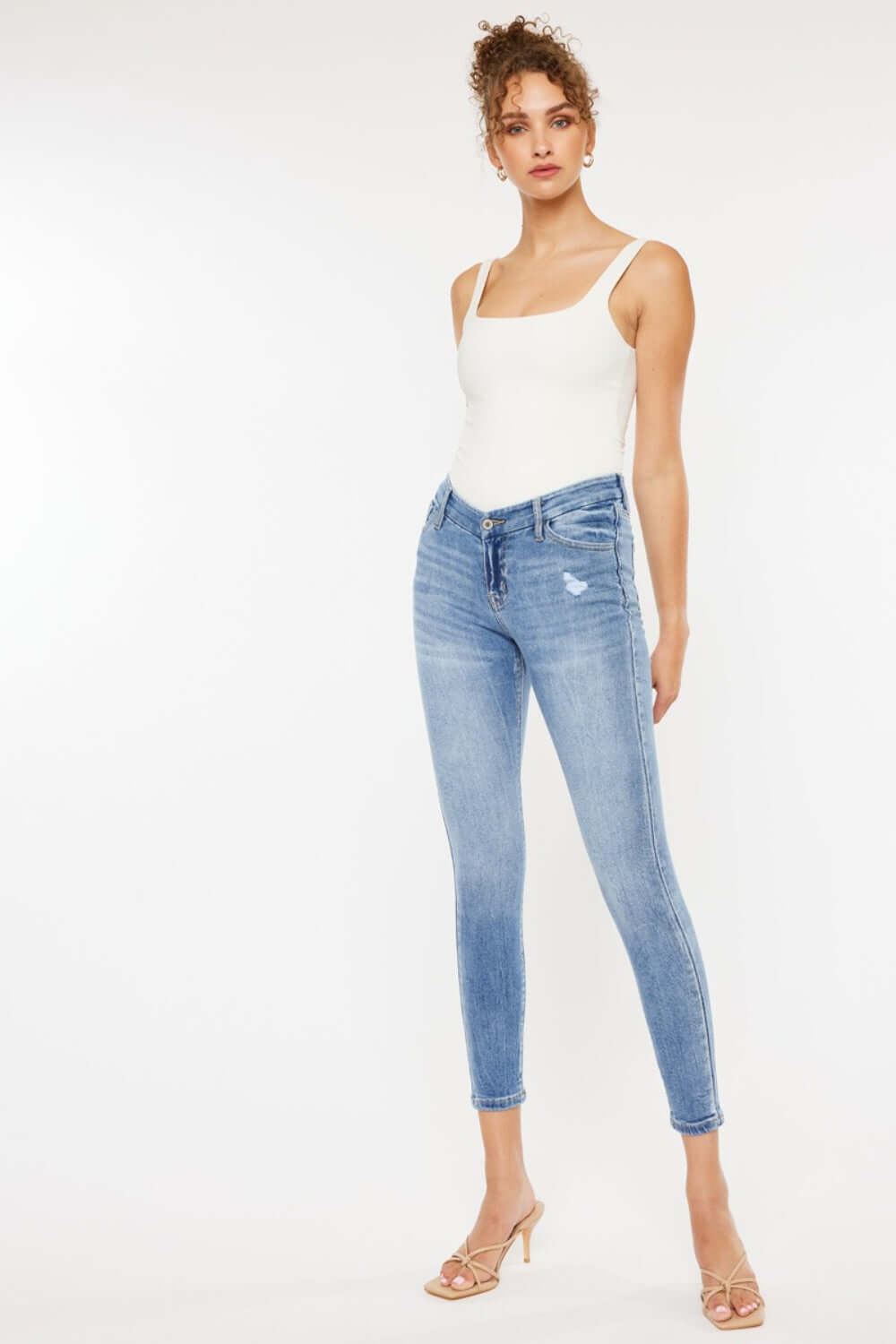 Woman wearing High Waist Cat's Whiskers Skinny Jeans with classic denim wash and distressed details, showcasing fashionable high-waist design.