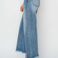 Side view of high-rise raw hem cropped wide leg jeans by Risen Jeans, perfect for a chic and stylish look.