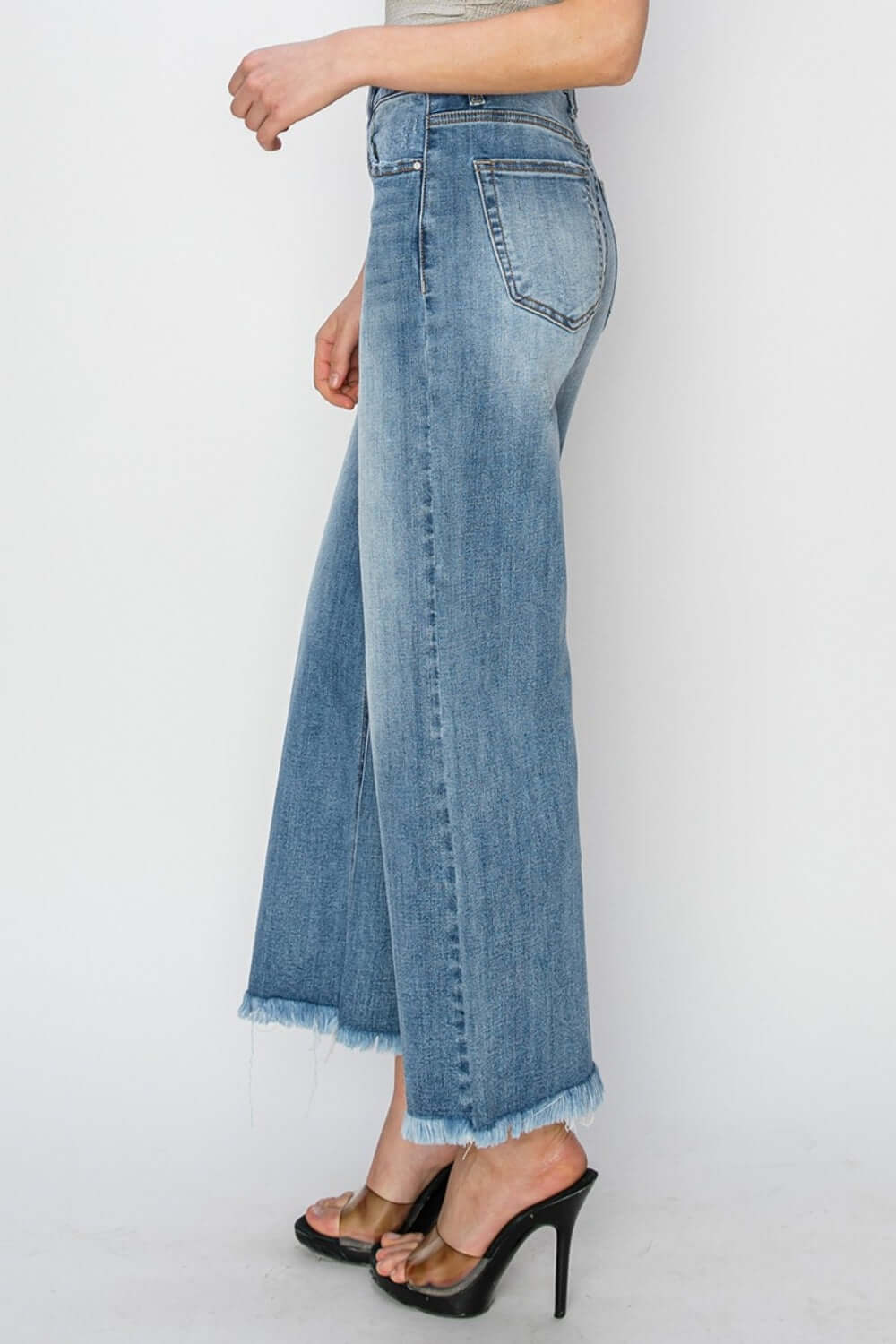 Side view of high-rise raw hem cropped wide leg jeans by Risen Jeans, perfect for a chic and stylish look.