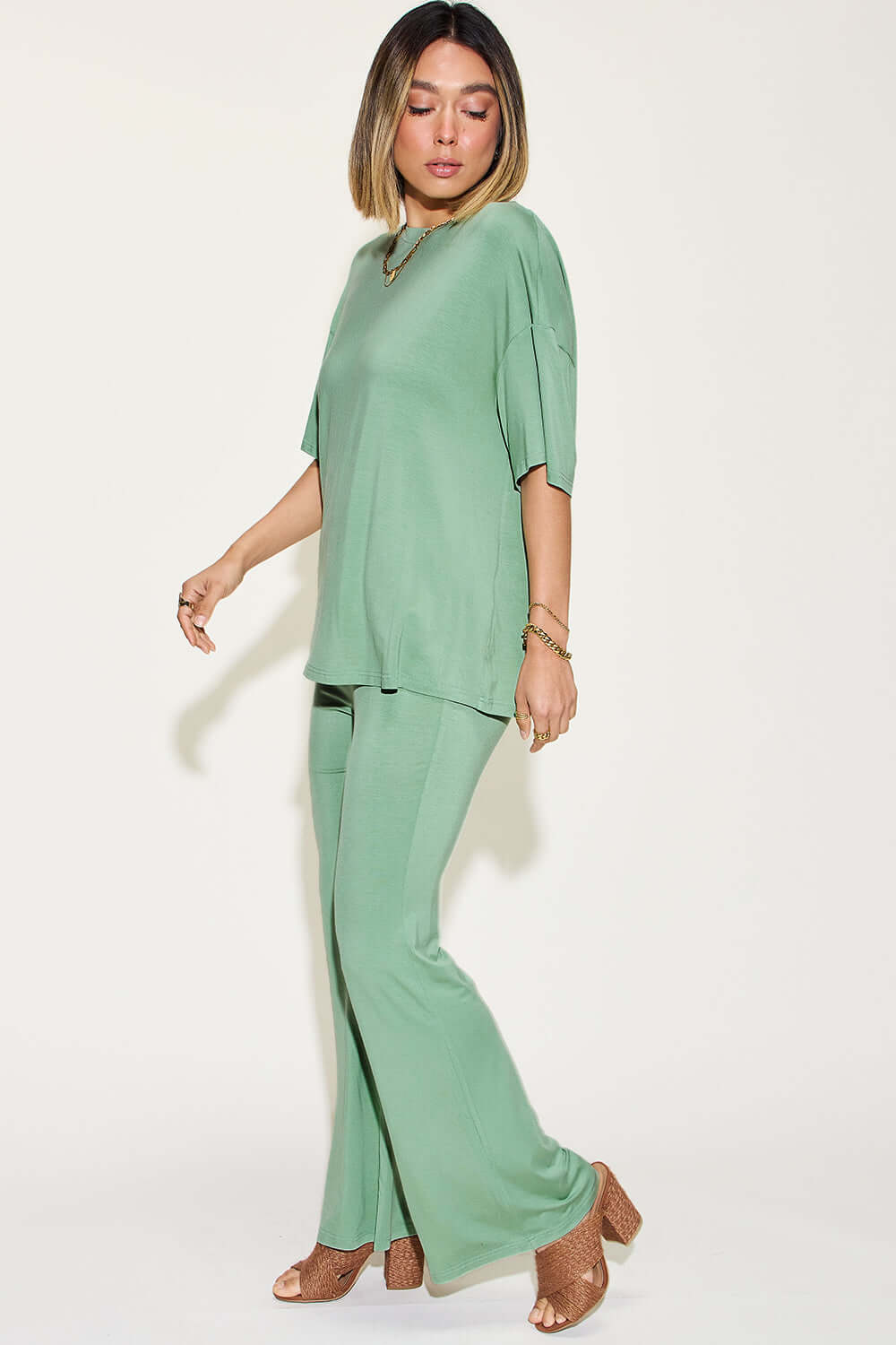 Woman wearing Bamboo Drop Shoulder T-Shirt and Flare Pants Set in green pastel. Two-piece set, stretchy bamboo fiber blend. Machine washable.