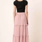 Woman wearing pink drawstring high waist frill skirt with black top, showcasing the back details of the skirt.