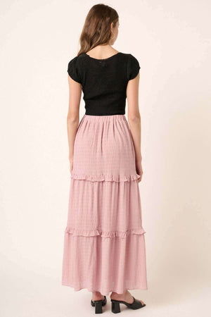 Woman wearing pink drawstring high waist frill skirt with black top, showcasing the back details of the skirt.