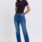 Model showcasing Judy Blue Mid-Rise Bootcut Jeans with thermal lining in a stylish, casual outfit.