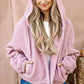 Woman wearing And The Why Sherpa Drawstring Cropped Hooded Jacket in pink, showcasing its cozy sherpa fabric and trendy style.