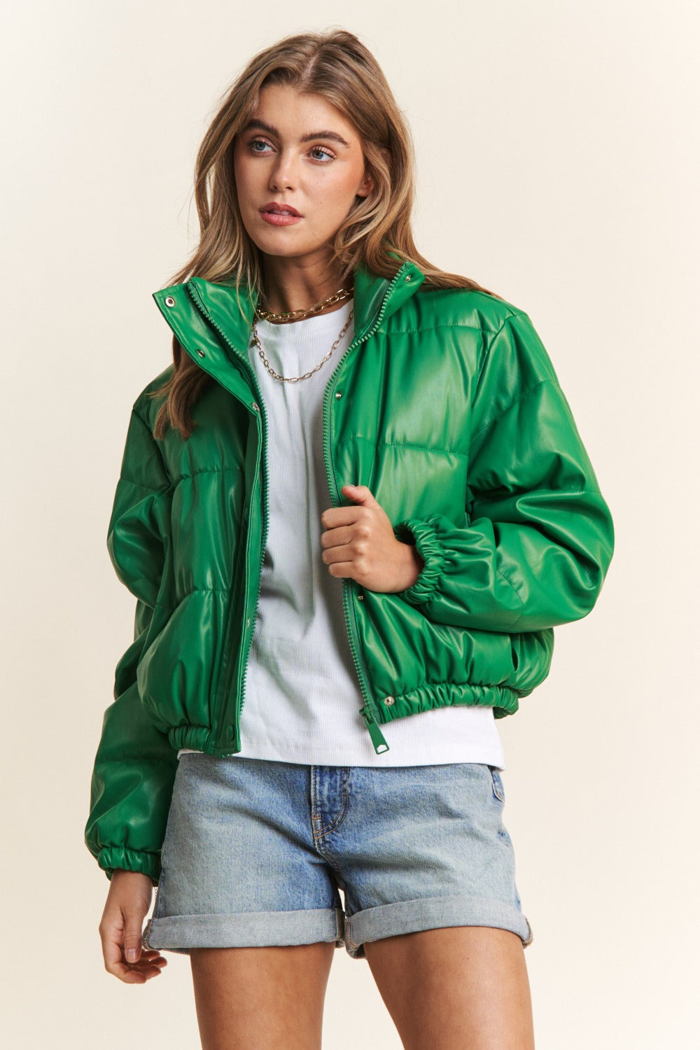 Chic green faux leather crop puff jacket with turtleneck, snap buttons, zipper closure, and drawstring hem; perfect for fall style.