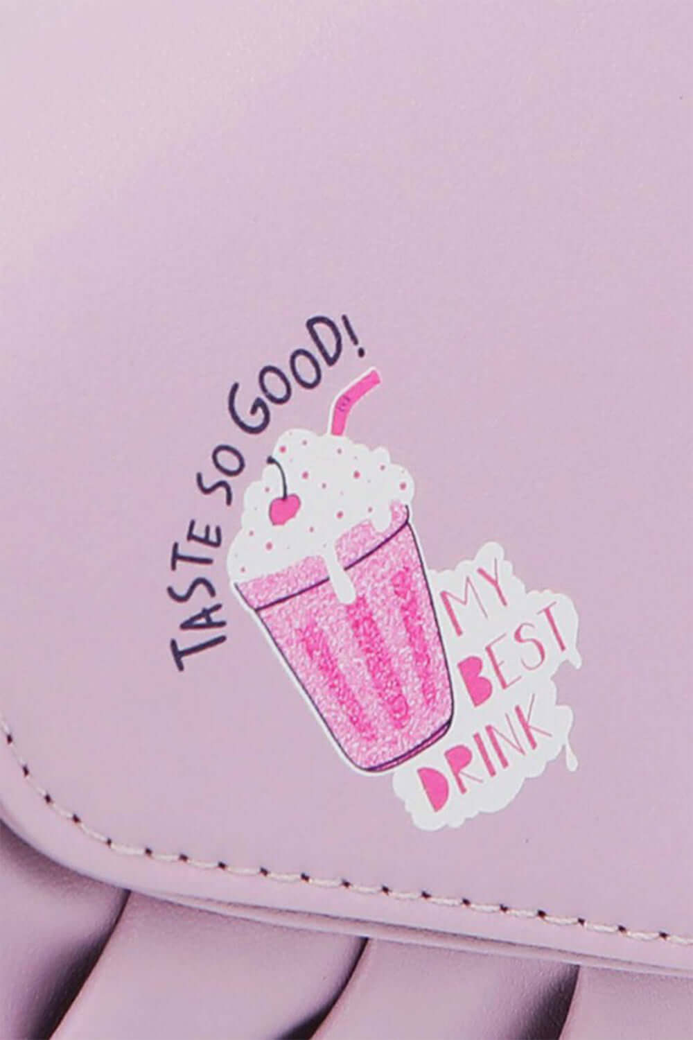 Close-up of Nicole Lee USA Graphic Crossbody Bag with "Taste So Good" and "My Best Drink" pink milkshake graphic design