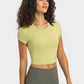 Woman in a cropped round neck short sleeve sports t-shirt, perfect for yoga, styled in soft lime green with leggings.