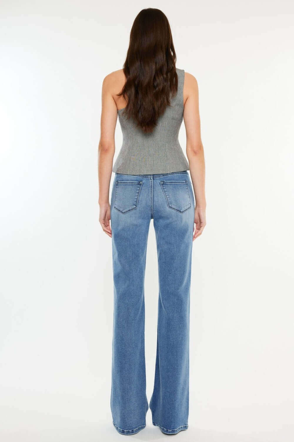 Back view of model wearing Ultra High Rise Cat's Whiskers Jeans in light blue, showcasing high-waisted fit and vintage whisker details.