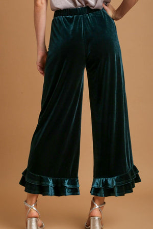 Back view of Umgee velvet wide fit ruffle pants showcasing embroidered pockets and ruffle hem detail.