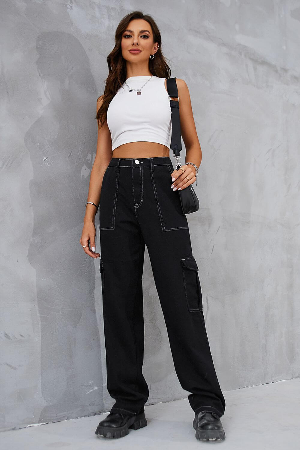 Woman wearing Baeful Long Straight Leg Jeans with pockets, paired with a white crop top and black bag, showcasing chic casual style.