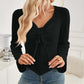 Woman wearing Bella Road Ribbed Drawstring Long Sleeve T-Shirt in black with slightly stretchy material, paired with denim jeans.