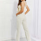 Woman wearing Taylor High Waist Overalls in white, styled with a tank top and heels, perfect for casual outings and family adventures.