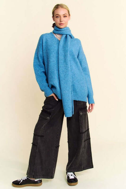 Stylish model in a blue V-neck dropped shoulder sweater with a scarf, paired with wide-leg cargo pants for a trendy look.