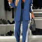 Stylish woman in a blue denim two-piece set with contrast lapel collar, featuring a blazer and matching pants.