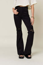 High Waist Distressed Flare Jeans by Judy Blue Jeans, featuring black fabric with ripped knees and vintage flair, modeled with a white crochet top