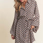 Woman wearing J.NNA geometric balloon sleeve midi dress with waist tie and trendy print.