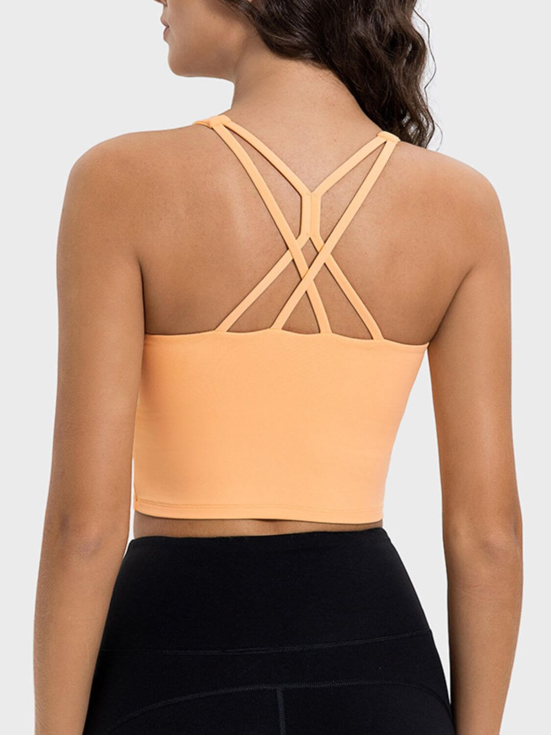 Back view of the Millennia Crisscross Round Neck Active Tank in peach, featuring stylish crisscross straps and a sleek design.