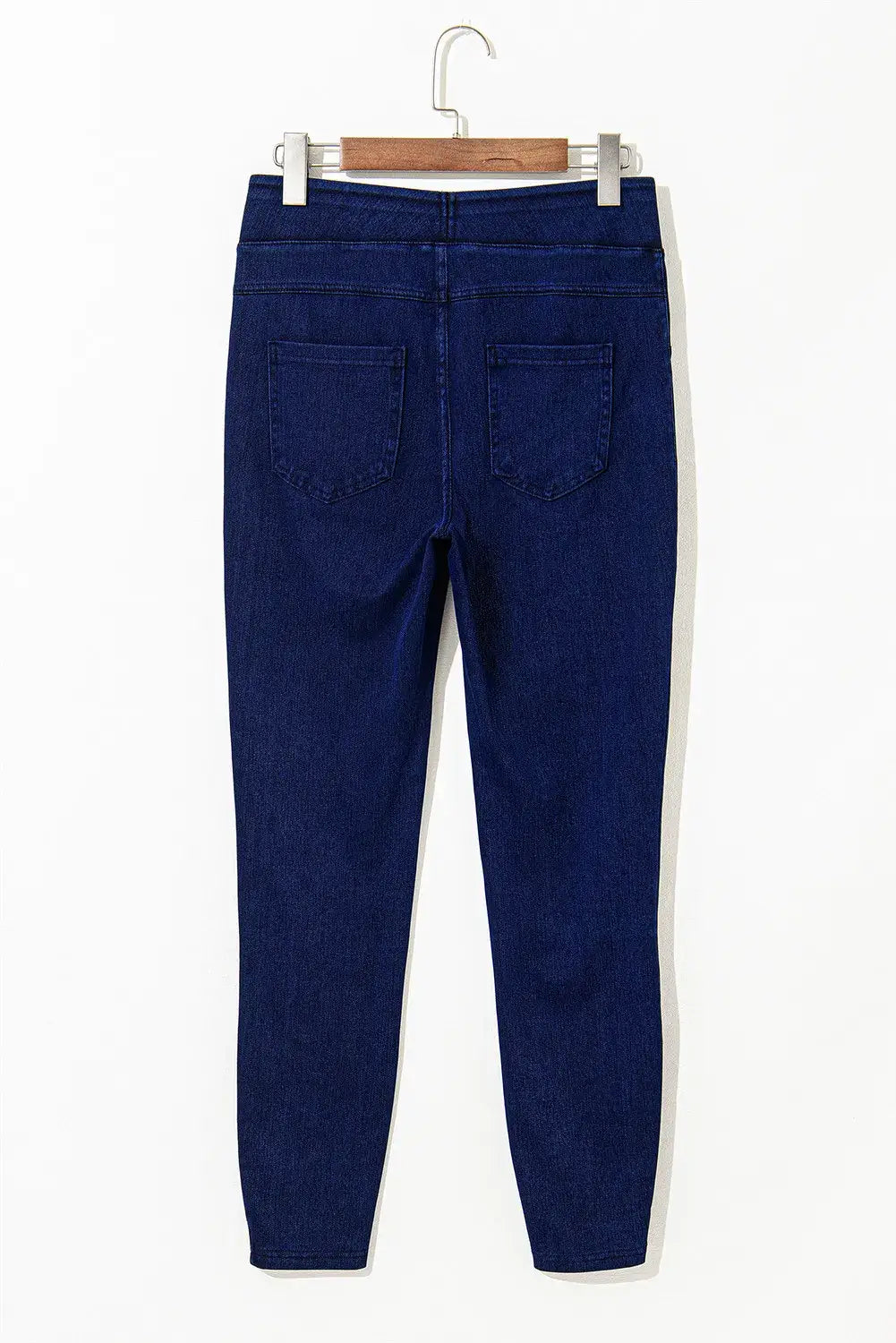 Skinny jeans with pockets in dark blue for petites with a perfect fit displayed on a hanger.