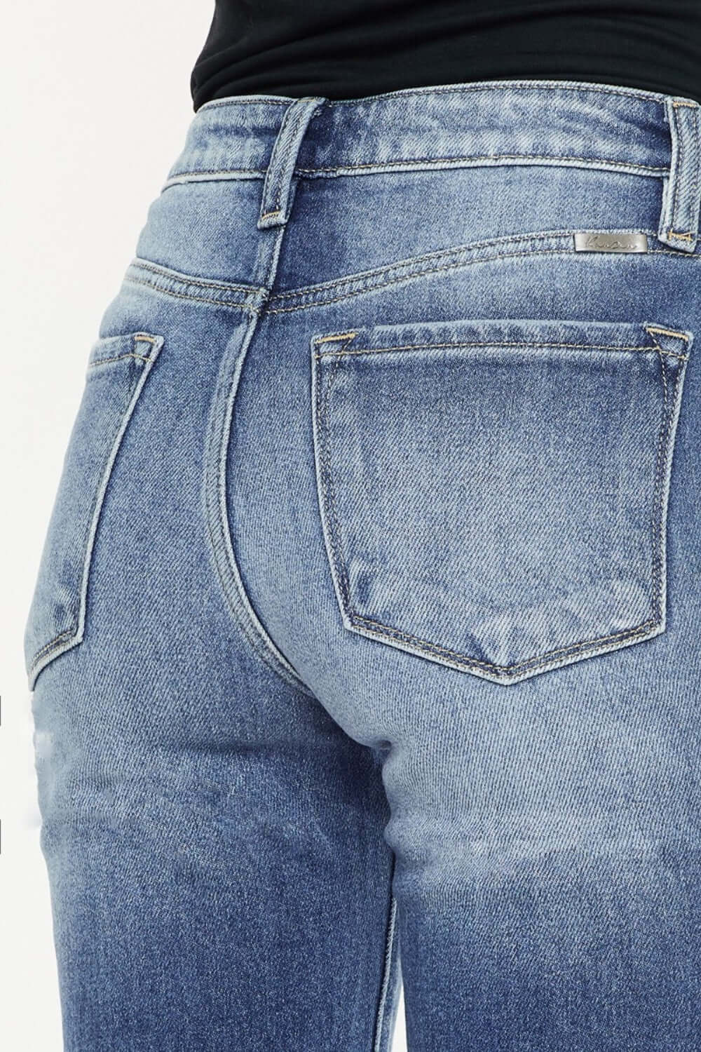 High waist distressed hem detail cropped straight jeans back view. Trendy edgy denim with a lived-in look, showcasing stylish rear pockets.