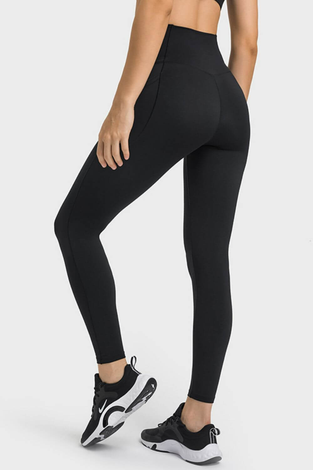 Black Millennia V-Waist Yoga Leggings with pockets, showcasing a flattering fit from the back, perfect for workouts.