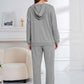 Woman wearing gray Bella Road Dropped Shoulder Hoodie and Pants Set, showcasing relaxed fit and cozy elegance for lounging or errands.