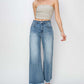 Stylish woman wearing high rise raw hem cropped wide leg Risen Jeans with a trendy blouse.