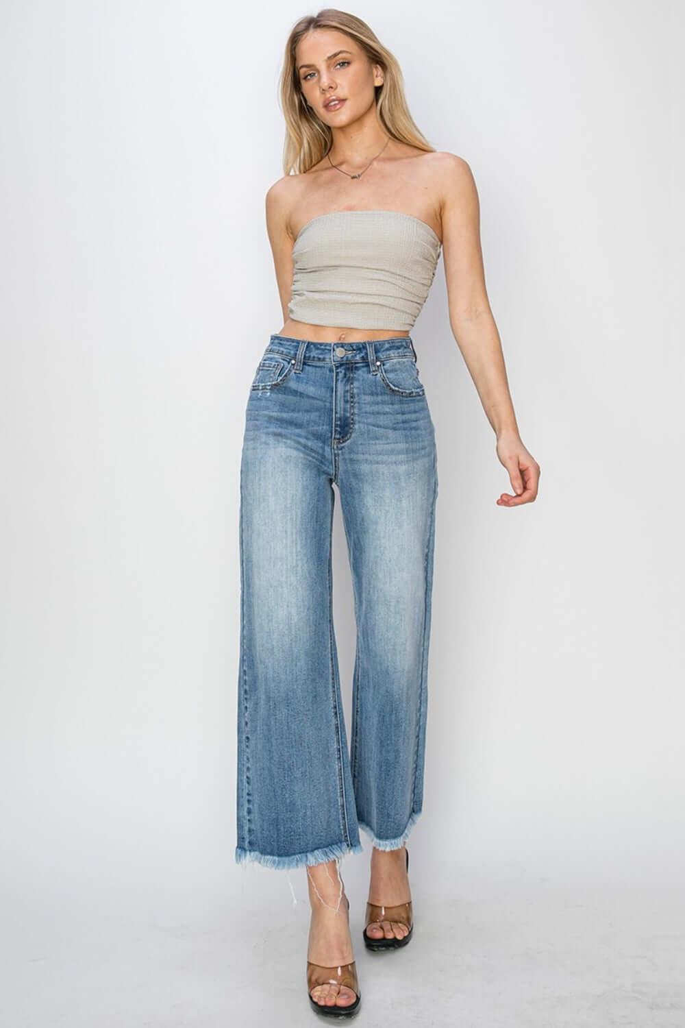 Stylish woman wearing high rise raw hem cropped wide leg Risen Jeans with a trendy blouse.