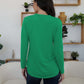 Woman wearing FAM-FAM round neck long sleeve t-shirt in vibrant green, showcasing back view, perfect for casual occasions.