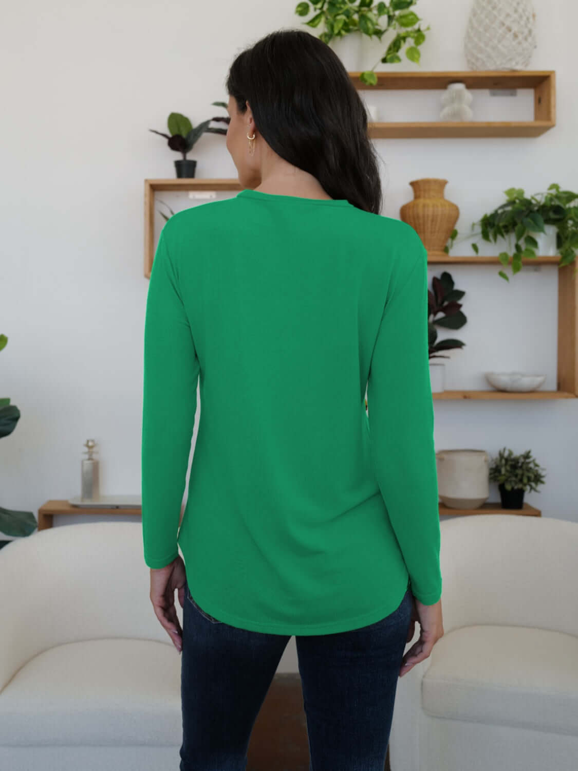 Woman wearing FAM-FAM round neck long sleeve t-shirt in vibrant green, showcasing back view, perfect for casual occasions.