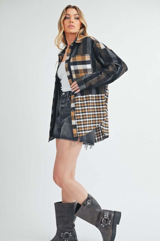 Trendy woman wearing Aem+Co plaid button-up shirt with curved hem, styled with denim shorts and stylish boots.