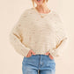 Woman wearing a cozy Dolman Sleeves Sweater in cream with blue jeans, showcasing its relaxed fit and trendy, versatile design.