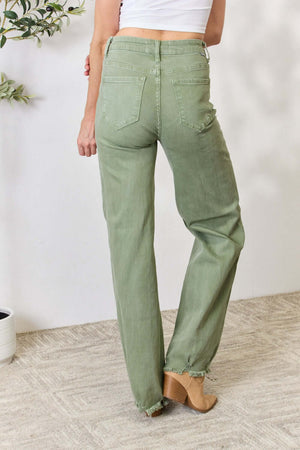 Woman wearing Risen Jeans raw hem wide-leg green jeans, showcasing the flattering high-waisted fit and trendy wide-leg design.