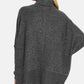 Woman wearing cozy brushed melange hacci turtleneck sweater in gray, perfect for layering and paired with jeans.