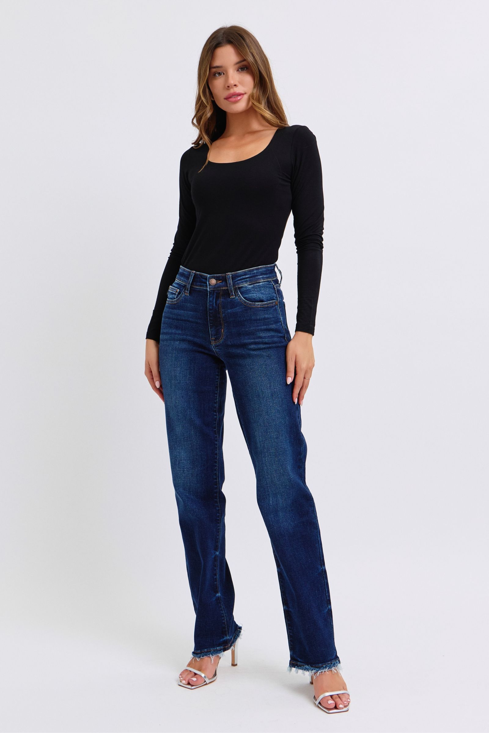 Woman wearing Judy Blue Full Size Raw Hem Straight Leg Jeans with a black top, showcasing a stylish and versatile look.