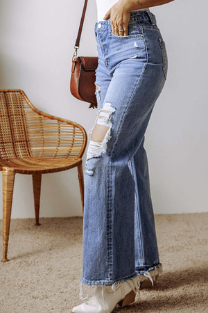 Woman wearing distressed straight leg jeans with raw hem and pockets, standing next to a wooden chair.