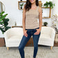 Woman wearing Classic Handsand Skinny Jeans by Judy Blue standing in living room with plants and stylish decor